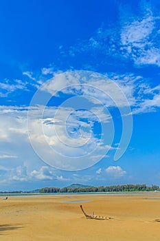 Old wreck fishing boat buried in the sand with blue sky on cloud