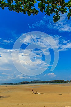 Old wreck fishing boat buried in the sand with blue sky on cloud