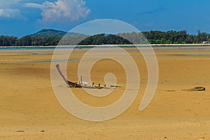 Old wreck fishing boat buried in the sand with blue sky on cloud