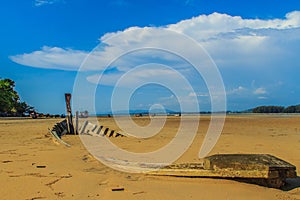 Old wreck fishing boat buried in the sand with blue sky on cloud