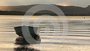 old yawl boat floating at sunset on the lake