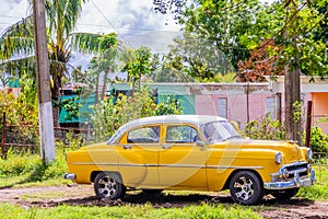 Old yellow american retro car parked in the countryside, Ciego De Avila, Cuba