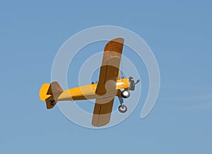 Old yellow biplane in flight