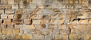 Old yellow and brown sandstone wall made of blocks of irregular shape  background