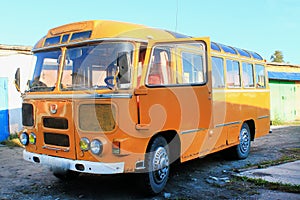 Old yellow bus in vintage style on a yellow background. Urban transport. Light vintage antique grunge texture. Antique