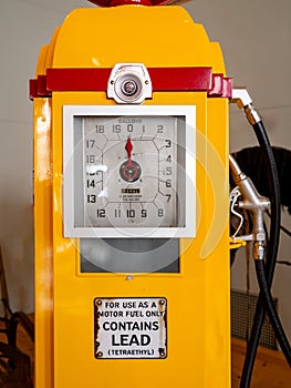 Old yellow gas pump close up with gallons dial