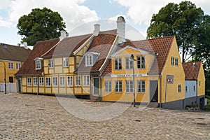 Old yellow houses in street with cobblestones