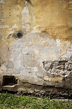 Old yellow plaster and brick wall