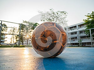 Old yellow soccer ball on the blue football field