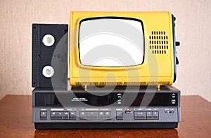 Old yellow vintage TV with white insulated screen to add new images to the screen, VCR in the background wallpaper.