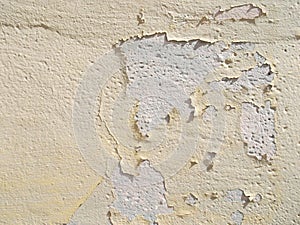 An old yellow wall with cracked paint