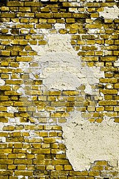 Old yellow wall with cracks and patches of plaster