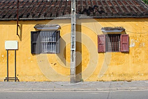 Old yellow wall, shutters wrought iron window, Hoi An, Vietnam