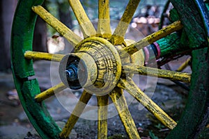 Old yellow wooden wheel of wagon