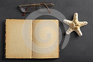Old yellowed notebook, glasses and seashells. A place to save your holiday memories