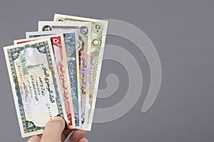 Old Yemeni money in the hand on a gray background