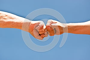 A old and young fist punching each other