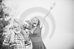 Old and Young. Grandfather and grandchild. Grandfather carrying his grandson on shoulders. Happy family - grandfather