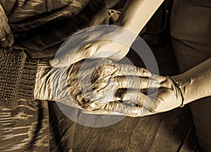 Old and young hands check hand sepia tone