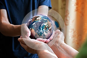 old and young person hands holding planet earth, unity concept. elements of this images furnished by nasa