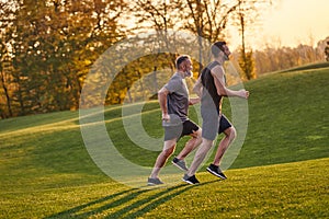The old and young sportsmen running in the green park.