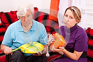 Old and young woman getting loveless gifts photo