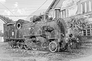 Old Yugoslavian locomotive near old train station, black and white