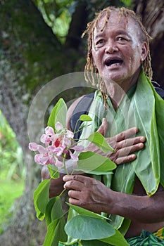 Olde aged Pacific Islander man explains about exotic flower on e