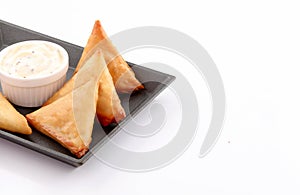 Olden samosa stuffed in black sizzling plate on white background
