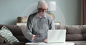 Older 70s man feels desperate and stressed calculating household expenses