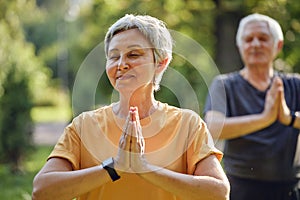 Older active couple do meditation practice outdoors