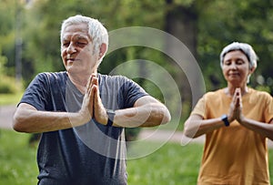 Older active couple do meditation practice outdoors