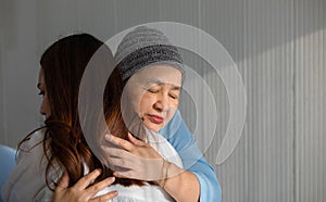 Older Asian woman patient covered the head with clothes effect from chemo treatment in cancer