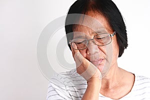 Older Asian women are sad because of toothache.