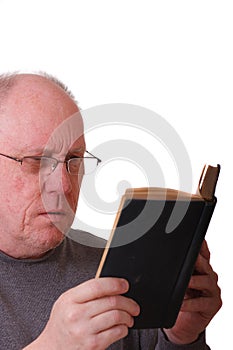 Older Balding Man Reading a Black Book or bible