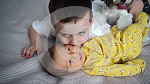 older brother with dog kisses newborn sister. birth of second child in family.