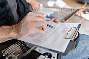 Older brother explains to his younger one how to use notes on music sheets on an exapmple