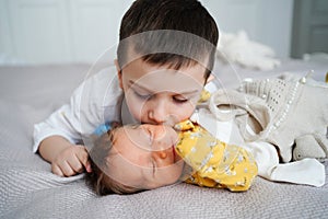 older brother kisses newborn sister. birth of second child in family.