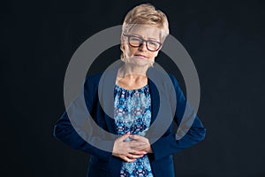Older businesswoman having stomach pain