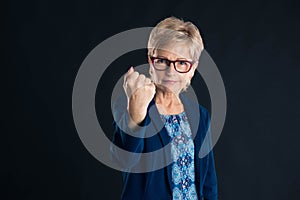 Older businesswoman showing you the fist