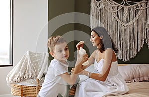 Older child c helping his mother to care for newborn baby at home