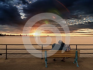 Older couple on bench enjoying Sunset photo