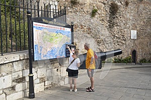 Older couple looking at large tourist map of Gibraltar.