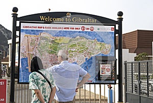 Older couple looking at large tourist map of Gibraltar.