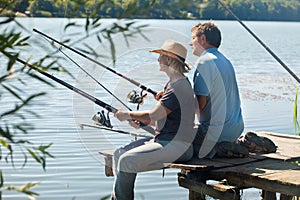 Older couple sitting on pontoon and fishing