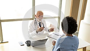 Experienced doctor explaining cardiogram to patient