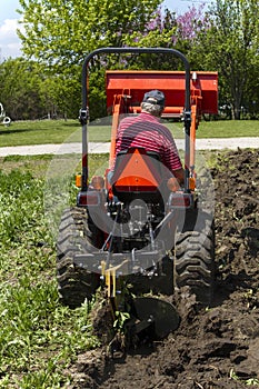 Older Farmer Plowing His Garden