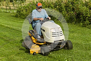 Older Gentleman Cutting Grass On Riding Lawnmower