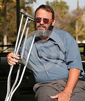Older gentleman holding crutches