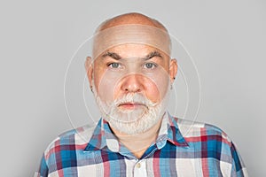 Older grandfather, grandpa pensioner, retiree concept. Portrait of an bald old mature senior man with grey beard in